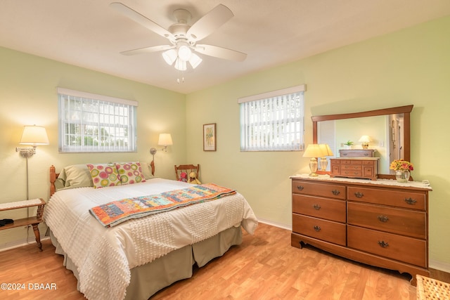 bedroom with light hardwood / wood-style floors, multiple windows, and ceiling fan