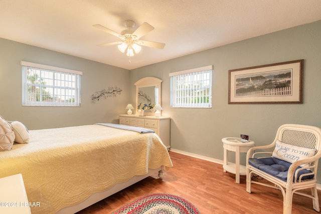 bedroom featuring multiple windows, ceiling fan, and wood-type flooring