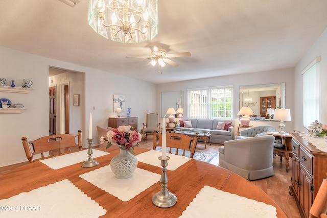 dining area featuring ceiling fan with notable chandelier and light hardwood / wood-style flooring