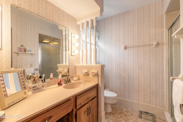 bathroom featuring tile patterned flooring, vanity, a shower with door, and toilet