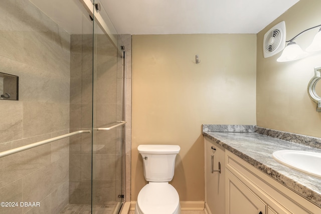 bathroom featuring toilet, an enclosed shower, and vanity