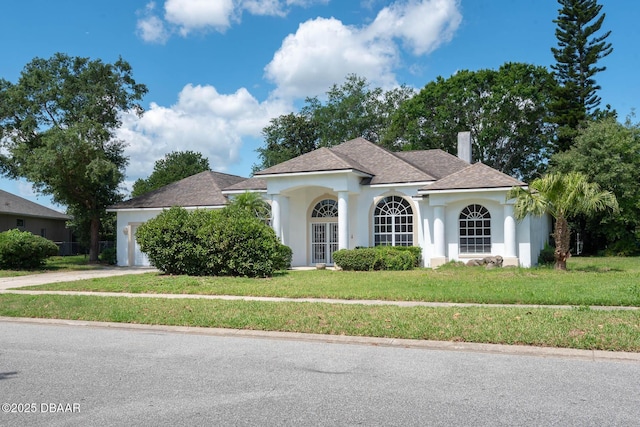 6062 Sabal Crossing Ct, Port Orange, FL 32128 - view of front of house with a garage, a front yard, stucco siding, a chimney, and driveway