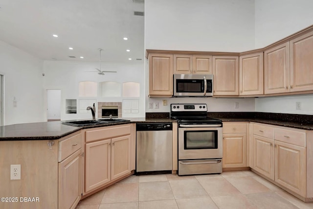 6062 Sabal Crossing Ct, Port Orange, FL 32128 - kitchen featuring appliances with stainless steel finishes, light brown cabinets, a sink, a peninsula, and ceiling fan