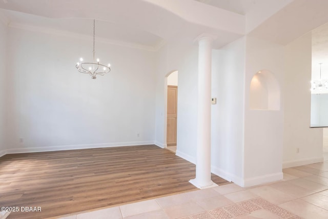 6062 Sabal Crossing Ct, Port Orange, FL 32128 - spare room featuring a chandelier, arched walkways, crown molding, light tile patterned flooring, and baseboards