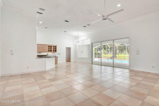 6062 Sabal Crossing Ct, Port Orange, FL 32128 - unfurnished living room with a towering ceiling, a ceiling fan, a chandelier, light tile patterned floors, and baseboards
