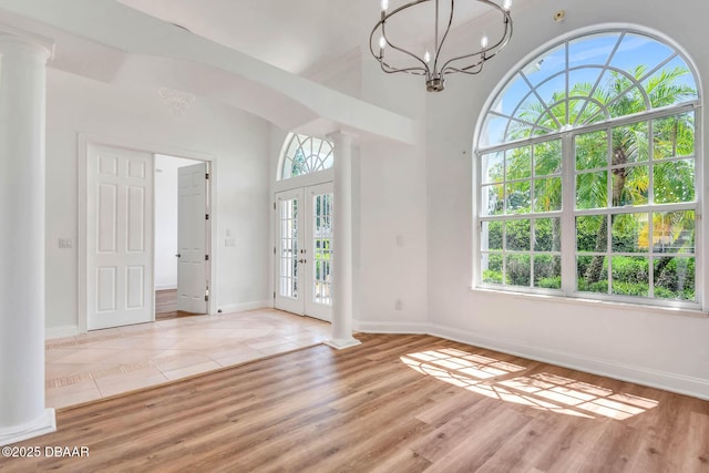 6062 Sabal Crossing Ct, Port Orange, FL 32128 - unfurnished room with ornate columns, baseboards, a chandelier, and light wood-style floors