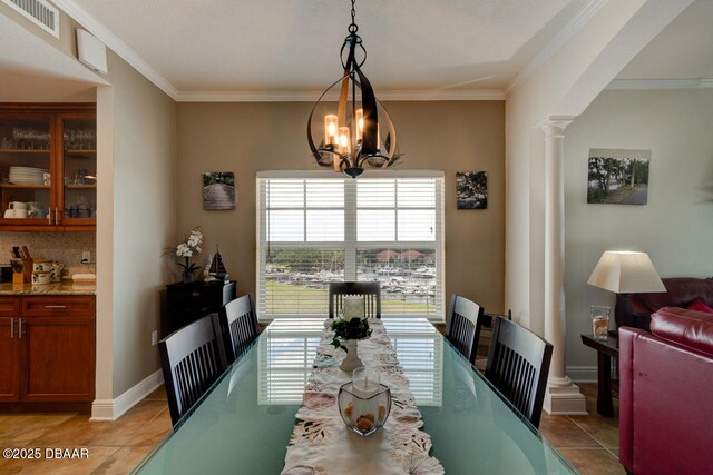 146 Palm Coast Resort Blvd Unit 501, Palm Coast, FL 32137 - dining area featuring decorative columns, light tile patterned floors, crown molding, and a chandelier
