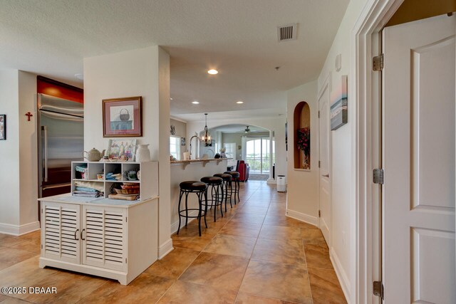 146 Palm Coast Resort Blvd Unit 501, Palm Coast, FL 32137 - hallway with arched walkways, a chandelier, recessed lighting, and light tile patterned floors