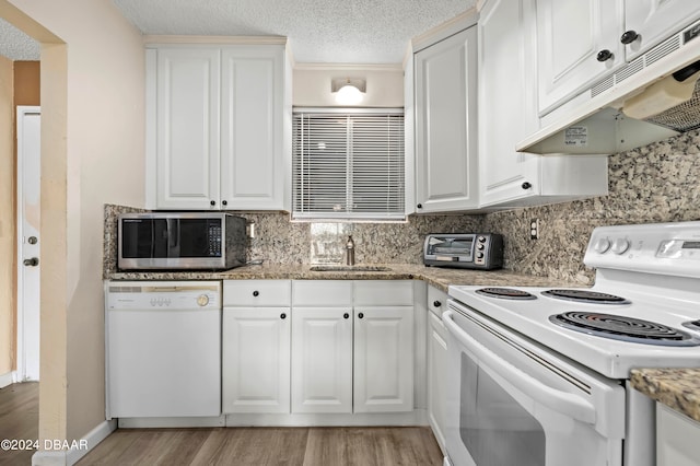 kitchen featuring white cabinetry, sink, and white appliances