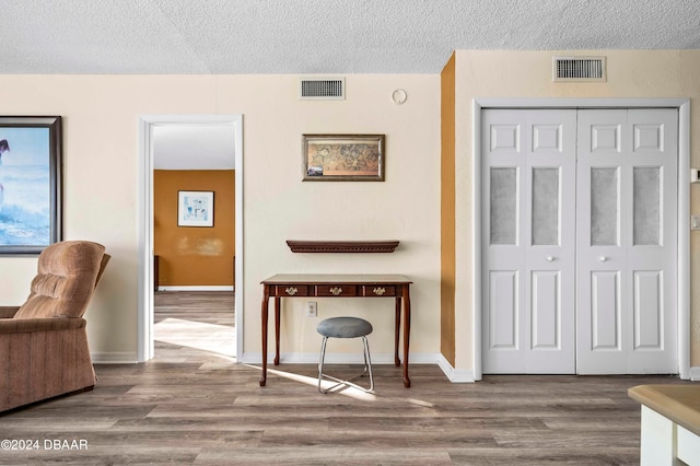 interior space with hardwood / wood-style flooring and a textured ceiling