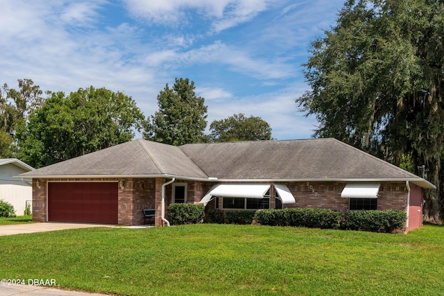 single story home with a garage and a front lawn