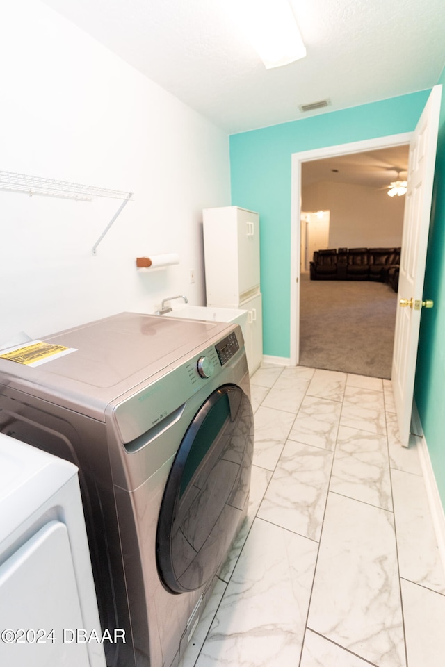 clothes washing area featuring separate washer and dryer and light colored carpet