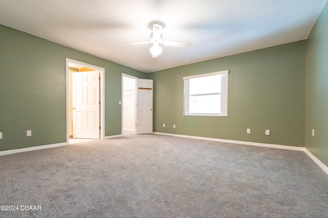 unfurnished bedroom with carpet, a textured ceiling, and ceiling fan