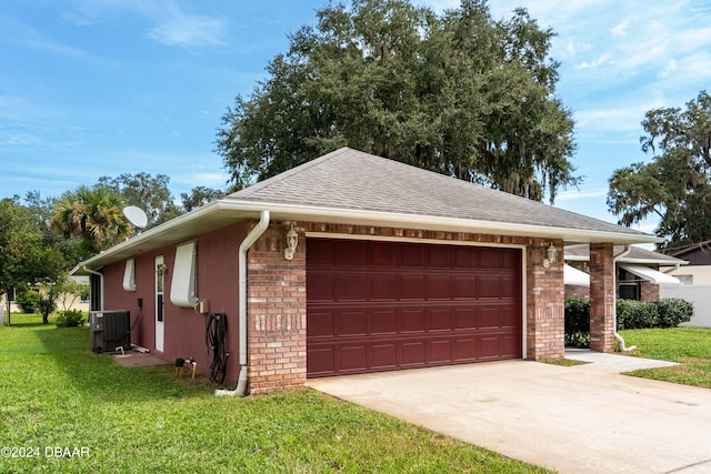 view of front of house featuring a garage, a front lawn, and central air condition unit