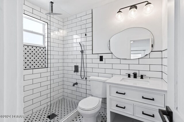 bathroom with toilet, backsplash, tile walls, and a tile shower