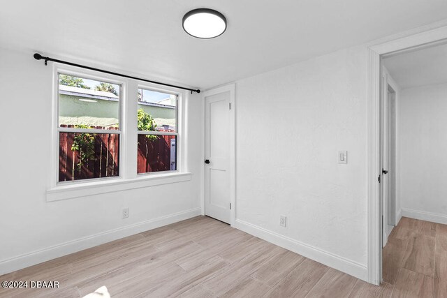 unfurnished room with light wood-type flooring