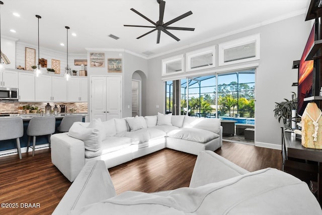 living room with dark hardwood / wood-style flooring, ornamental molding, and ceiling fan