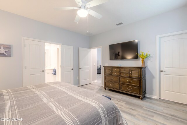 bedroom with a ceiling fan, baseboards, visible vents, light wood-style floors, and ensuite bath