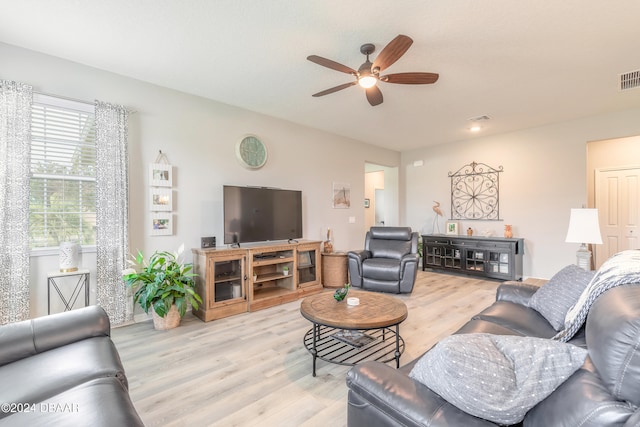 living area with light wood-style flooring, visible vents, and ceiling fan