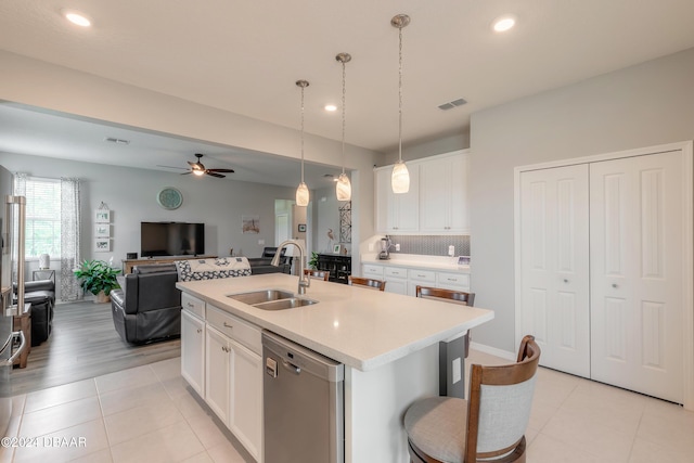 kitchen with visible vents, dishwasher, a kitchen island with sink, light countertops, and a sink