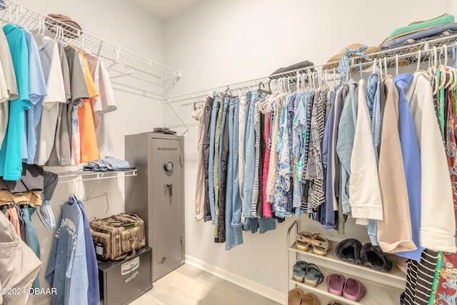 walk in closet with wood finished floors