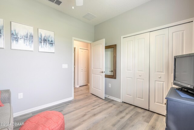 bedroom featuring light wood-style flooring, a closet, visible vents, and baseboards