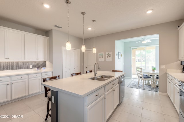 kitchen with stainless steel appliances, tasteful backsplash, visible vents, white cabinets, and a sink