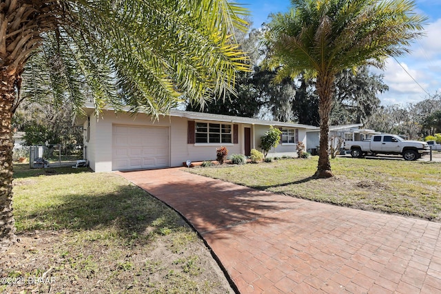 ranch-style house featuring a garage and a front lawn