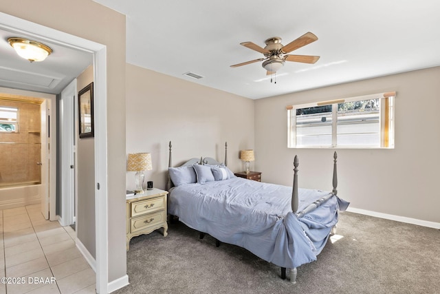 bedroom featuring ceiling fan, connected bathroom, multiple windows, and light tile patterned floors