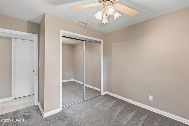 unfurnished bedroom with light carpet, ceiling fan, and a closet