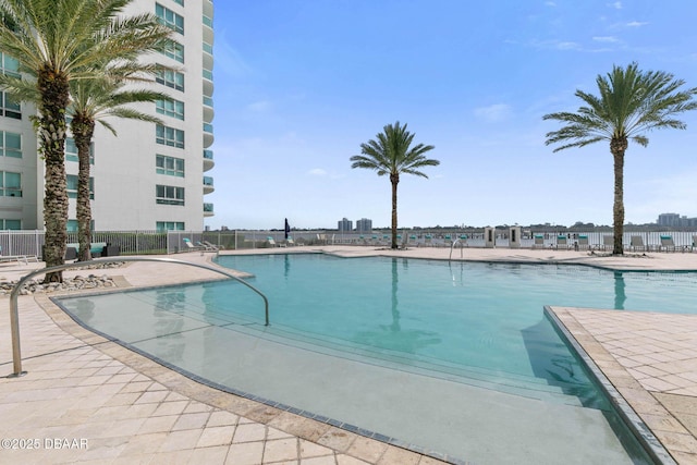 pool with a patio area and fence