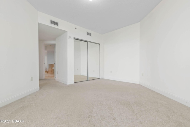 unfurnished bedroom featuring baseboards, a closet, visible vents, and carpet flooring