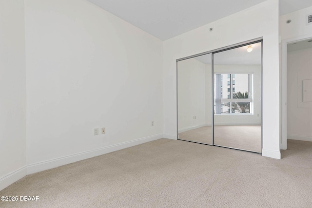 unfurnished bedroom featuring a closet, carpet flooring, visible vents, and baseboards