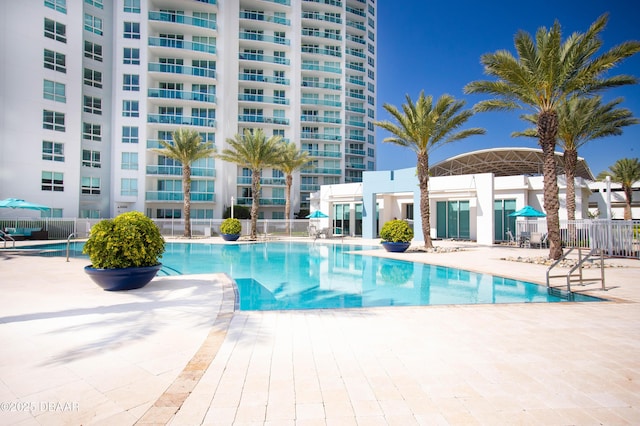 pool featuring fence and a patio