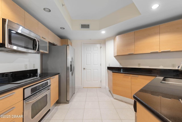 kitchen with visible vents, a raised ceiling, stainless steel appliances, a sink, and recessed lighting