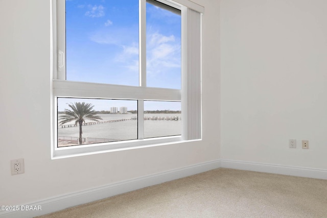 carpeted empty room with baseboards