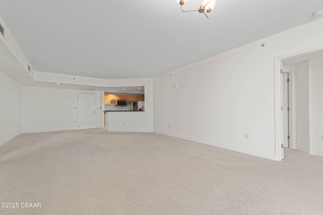 unfurnished living room with light colored carpet and baseboards