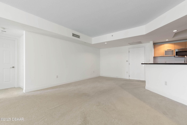 unfurnished living room featuring light carpet, baseboards, visible vents, and recessed lighting