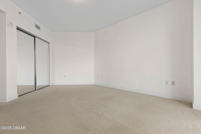 unfurnished bedroom featuring a closet, carpet flooring, visible vents, and baseboards