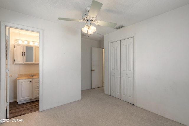 unfurnished bedroom featuring ceiling fan, a closet, connected bathroom, and a textured ceiling