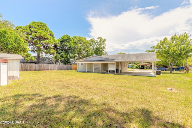 back of house featuring a yard and a carport