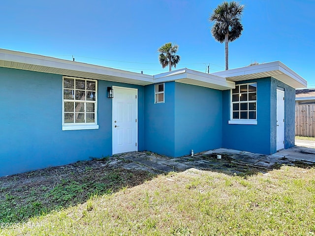 view of front of property with stucco siding and fence