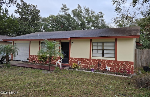 ranch-style house with a garage and a front lawn