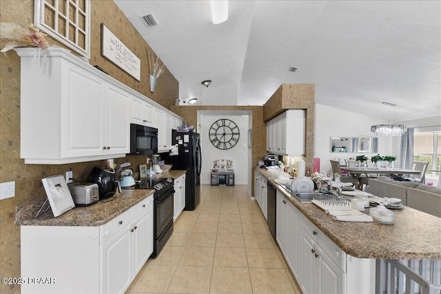 684 Aldenham Ln, Ormond Beach, FL 32174 - kitchen with black appliances, vaulted ceiling, white cabinetry, light tile patterned floors, and a peninsula