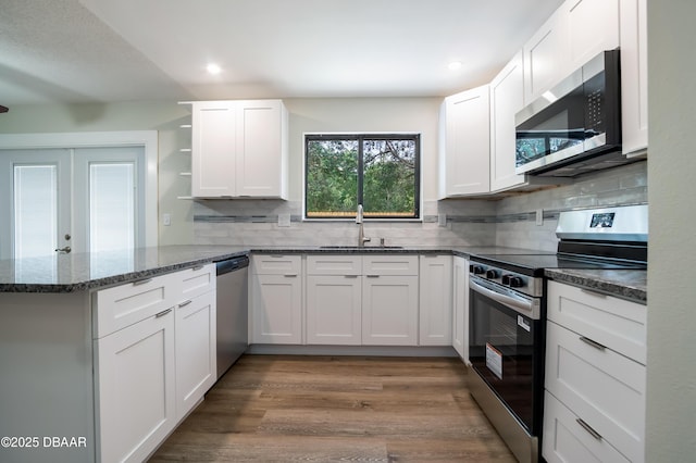 170 Dix Ave, Ormond Beach, FL 32174 - kitchen with appliances with stainless steel finishes, a sink, a peninsula, open shelves, and white cabinets