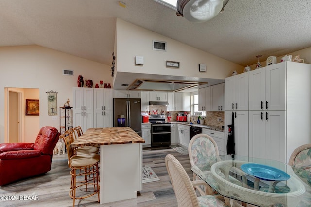 144 Herring Gull Ct, Daytona Beach, FL 32119 - kitchen with fridge with ice dispenser, wooden counters, stainless steel range with electric cooktop, light wood-style flooring, and a kitchen breakfast bar