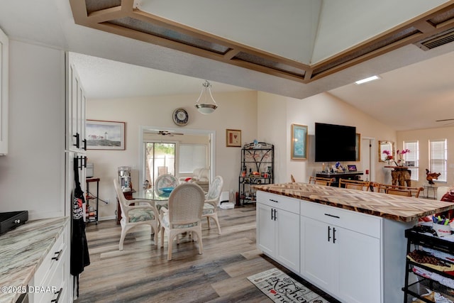 144 Herring Gull Ct, Daytona Beach, FL 32119 - kitchen featuring butcher block countertops, lofted ceiling, healthy amount of natural light, white cabinets, and wood finished floors