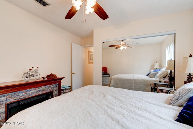 144 Herring Gull Ct, Daytona Beach, FL 32119 - bedroom featuring a stone fireplace, ceiling fan, and a closet