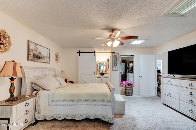 144 Herring Gull Ct, Daytona Beach, FL 32119 - bedroom with a barn door, light carpet, a textured ceiling, and ceiling fan