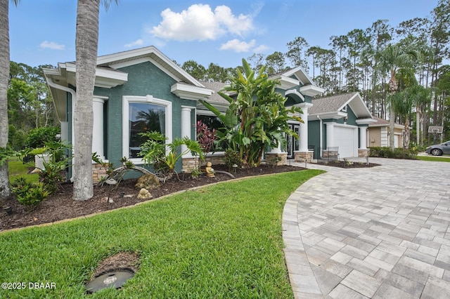 109 Edward Dr, Palm Coast, FL 32164 - view of front facade with decorative driveway, a front lawn, an attached garage, and stucco siding
